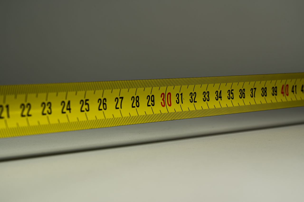 Close-up view of a yellow measuring tape with centimeter marks, emphasizing precision in measurement.